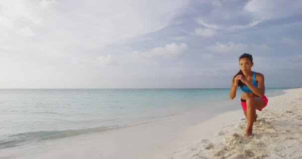 Omvänd Lunge motion - Fitness kvinna styrketräning ben övningar på stranden — Stockvideo