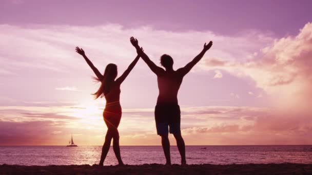 Desfrute de bem-estar e sucesso - casal feliz na praia desfrutando do pôr do sol — Vídeo de Stock