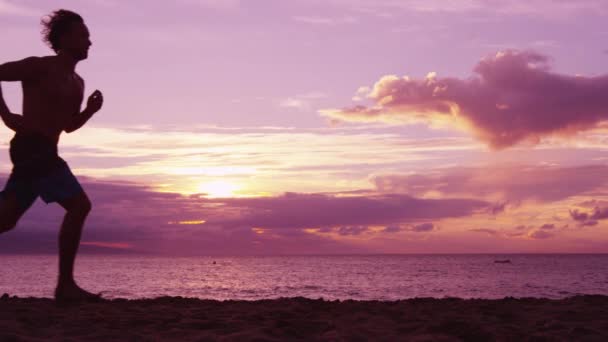 Silhouet van hardloop- en joggingtraining bij zonsopgang op het strand — Stockvideo