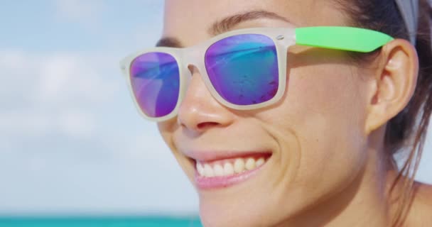 Yaz kumsalında gülümseyen kadın güneş gözlüğü takıyor. — Stok video