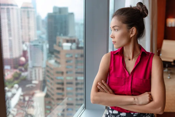 Ouvrière de bureau prenant une pause coûteuse regardant par la fenêtre pensant à des idées futures. Femme d'affaires asiatique confiante regardant skyline dans le centre-ville en Chine, Asie — Photo