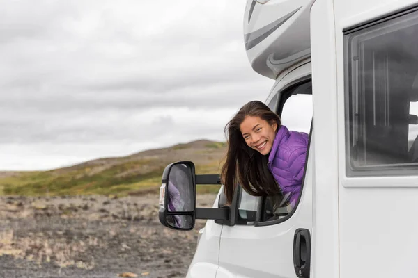 RV camper trailer travel woman driving motorhome camping van on Iceland road trip. Asian tourist driver smiling peeking out window of front seat — Stock Photo, Image