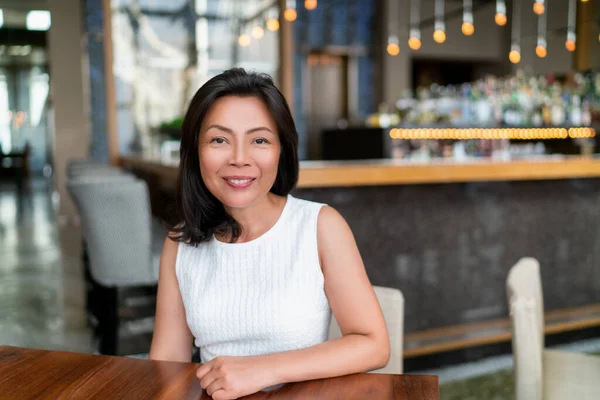 Asian middle age business woman smiling portrait. Happy elegant mature Chinese businesswoman lady in fancy restaurant setting — Stock Photo, Image