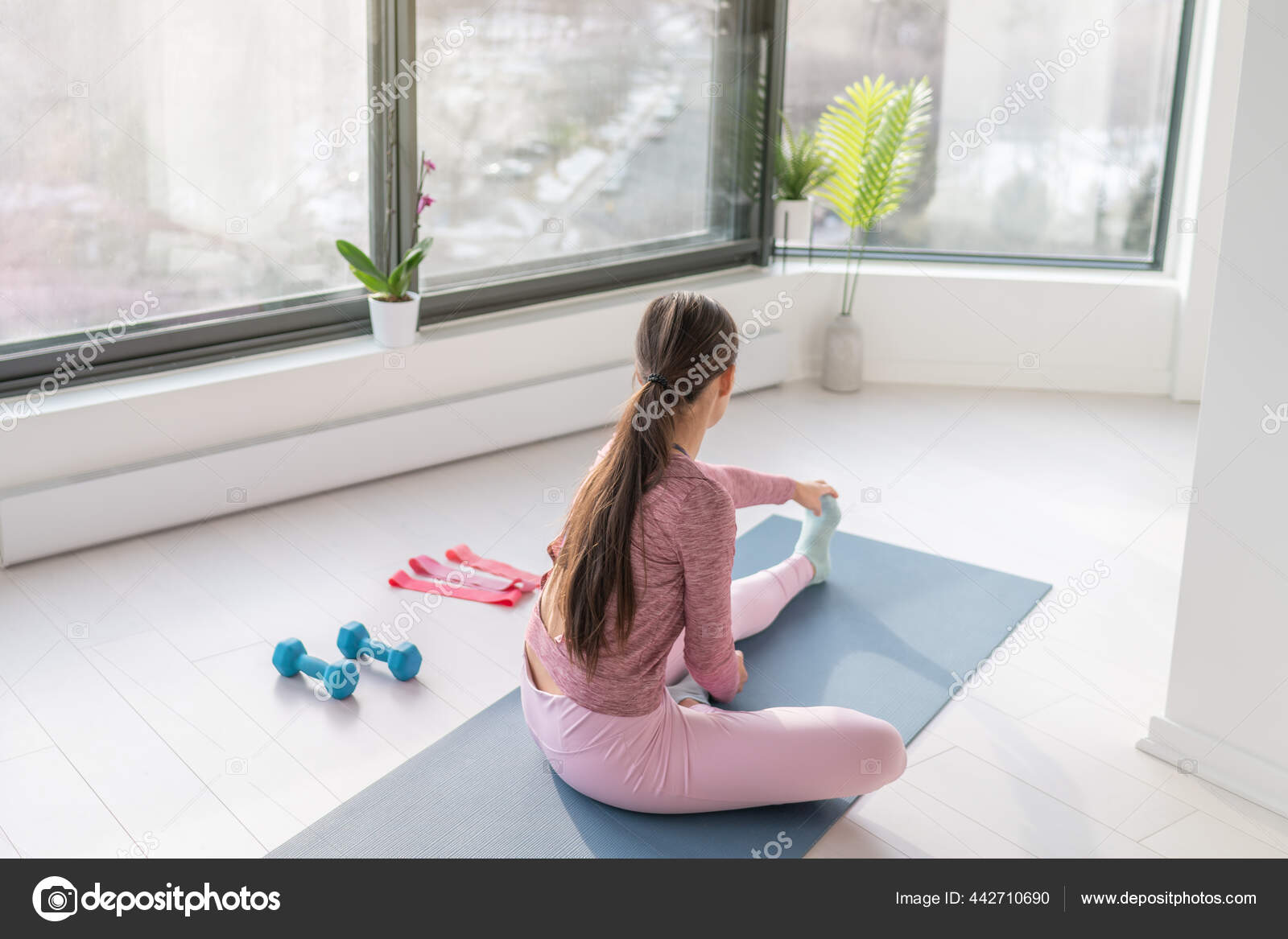 Mujer haciendo ejercicio en casa estirando las piernas antes del  entrenamiento de yoga. Fitness en casa