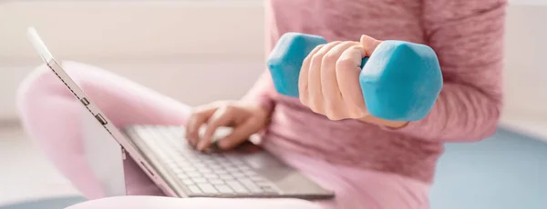 Vrouw met laptop thuis fitnessvideo 's online training klasse training met halter gewicht. Fit meisje met behulp van gewichten uit te werken armen banner panoramisch — Stockfoto