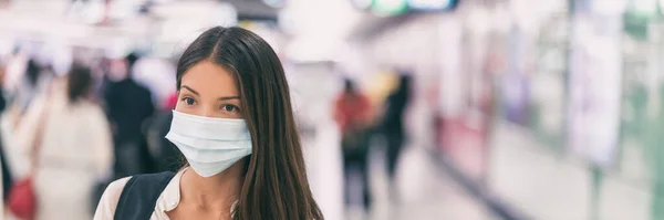 Coronavirus corona virüsü taşıyan, grip maskesi takan Asyalı kadın işe giderken kamu uzay taşımacılığı tren istasyonunda ya da havaalanı panoramik pankartıyla seyahat ediyor. — Stok fotoğraf