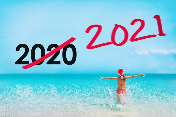 Nouvel An 2021. La pandémie de coronavirus 2020 est terminée. Touriste avec santa chapeau heureux d'être libre de voyager à nouveau à la plage des Caraïbes. Conception graphique texte — Photo