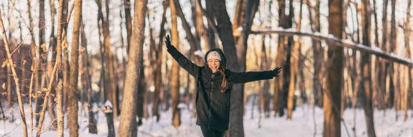 Alegria de inverno Menina asiática feliz se divertindo dançando com os braços abertos na floresta nevada paisagem banner panorama - Mulher tempo frio desfrutando de caminhada ao ar livre trilha caminhada na natureza — Fotografia de Stock