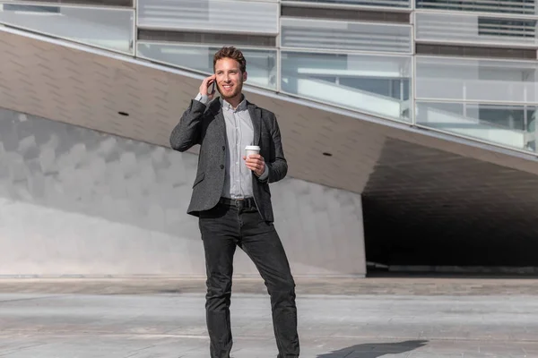 Junger Geschäftsmann telefoniert in der Kaffeepause aus einem Bürogebäude draußen mit dem Handy. Geschäftsmann zu Fuß auf der Straße pendeln Lebensstil — Stockfoto