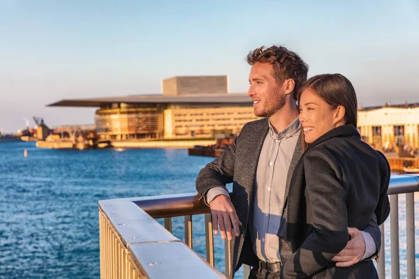 Avrupalı turistler, Danimarka 'nın Danimarka kentindeki Kopenhag limanında günbatımı manzarasının keyfini çıkarıyorlar. Asyalı kadın, Danimarkalı adam ırklar arası insanlar. — Stok fotoğraf