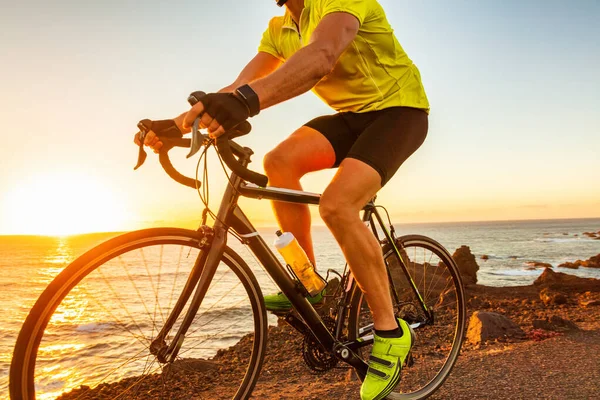 Bike race at sunset road biking cyclist riding bicycle outdoor with sun flare closeup of legs and yellow cycle shoes — Stock Photo, Image