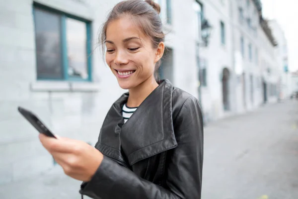 Azjatka przechadzająca się ulicą miasta, korzystająca z wiadomości tekstowych w aplikacji online na telefon komórkowy na zewnątrz. Miejski styl życia fajnych ludzi. Technologia — Zdjęcie stockowe