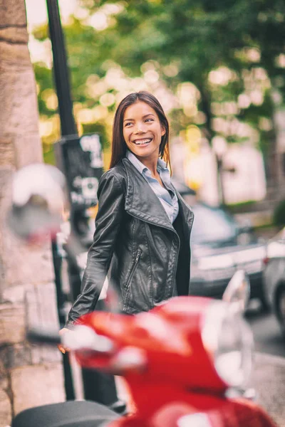 Asiatische Model-Frau zu Fuß in Europa, nachdem sie ihr rotes Moped auf der Straße geparkt hatte. Mit dem Auto durch die Stadt fahren und dabei urbanen Lebensstil genießen. Cooles Mädchen in schwarzer Lederjacke für den Herbst — Stockfoto