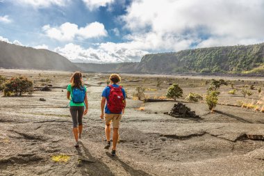 Couple tourists hikers walking on Kilauea Iki crater trail hike in Big Island, Hawaii. USA summer travel vacation destination for outdoor nature adventure, american tourism clipart