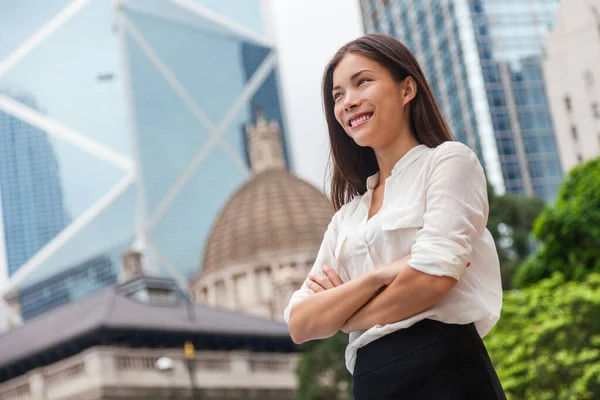 Donna d'affari asiatica fiduciosa a Hong Kong. Donna d'affari in piedi all'aperto guardando in alto nella speranza per la carriera futura con sfondo della città. Giovane professionista caucasico cinese multirazziale a Hong Kong — Foto Stock