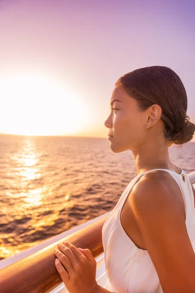 Crucero mujer de viaje de lujo vacaciones destino de Europa. Chica disfrutando de la vista del atardecer en elegante vestido de noche blanco desde la terraza suite balcón. asiático belleza relajante — Foto de Stock