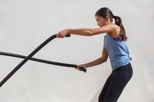 フィットネス女性トレーニングジムでの戦闘ロープワークアウト。女の子ワークアウト腕と心臓で使用して戦いロープのためのクロスフィット演習 — ストック写真