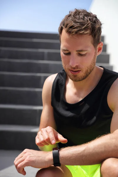 Chytrý běžec se dotýká sportovních hodinek a připravuje se na běh po schodech. Zdravý aktivní životní styl běžící mužský atlet cvičení — Stock fotografie