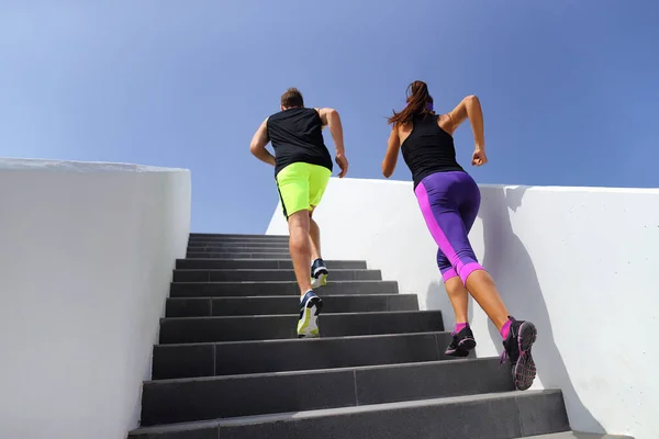 フィットネスジムで階段を駆け上がるカップル。市内でカーディオクライミングの階段を行使健康的なアクティブなライフスタイルスポーツの人々 — ストック写真