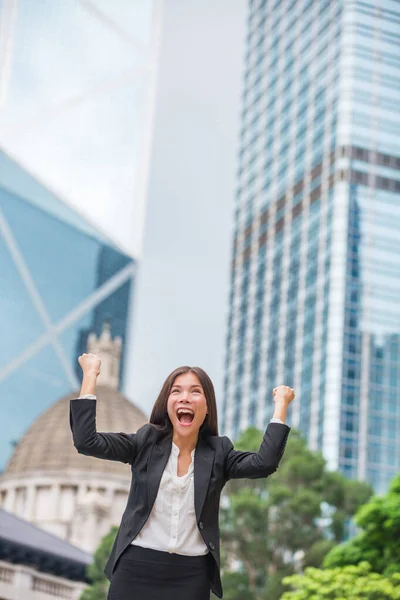 Mulher de negócios feliz sucesso em Hong Kong comemorando negócios bem sucedidos com as mãos levantadas no ar ganhando. Jovem multirracial chinês asiático caucasiano profissional — Fotografia de Stock