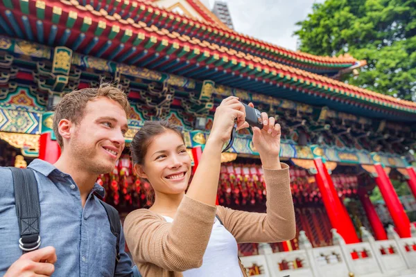 Hong Kong turistas casal visitando atração Wong Tai Sin Temple tirar foto selfie no marco de Hong Kong. Ásia China viagem sightseeing templo taoísta. Mulher asiática, homem caucasiano — Fotografia de Stock