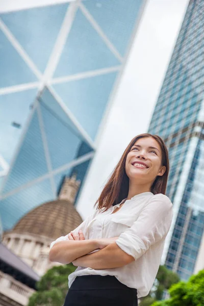 Mujer de negocios asiática confiada en Hong Kong. Mujer de negocios de pie al aire libre mirando hacia arriba en la esperanza de una futura carrera con antecedentes de la ciudad. Joven profesional chino multirracial caucásico en Hong Kong — Foto de Stock