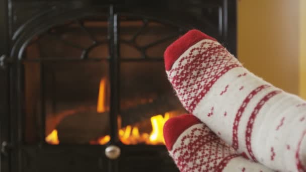 Mujer pies en calcetines llegar caliente contra el fuego cada vez más cálido y acogedor en invierno — Vídeo de stock