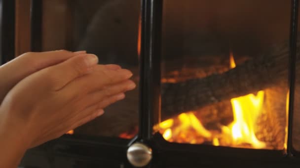 Las manos de la mujer frotando por la chimenea consiguiendo caliente frotando las manos juntas — Vídeo de stock