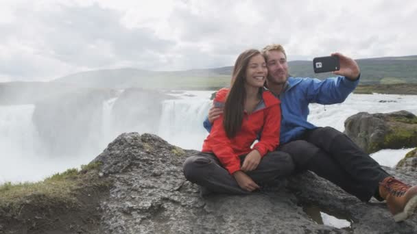 Happy Couple prenant téléphone Selfie contre la cascade - Destination touristique Islande — Video