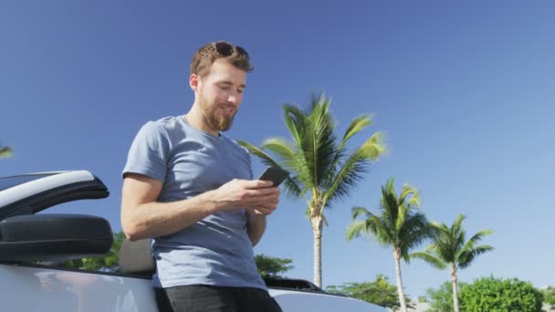 Hombre usando Smartphone apoyado en coche convertible - Profesional masculino con éxito — Vídeos de Stock