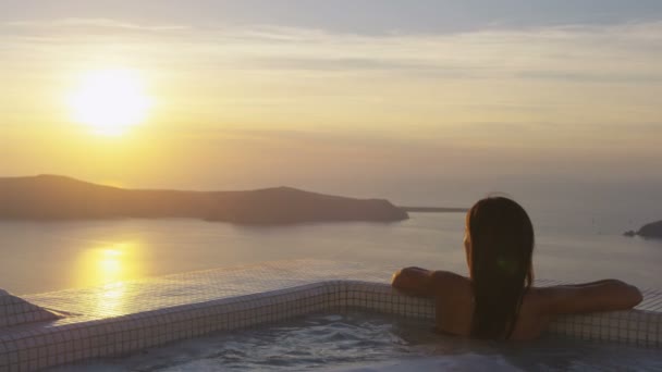 Азіатська жінка розслабляється в басейні курорту під час заходу сонця на подорожі відпустка — стокове відео