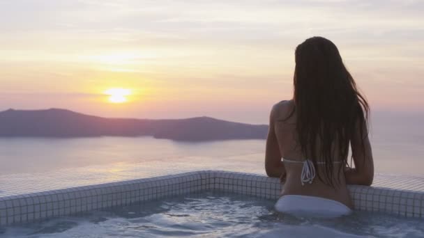 Kvinna i poolen njuter av solnedgången över havet på semester semester — Stockvideo