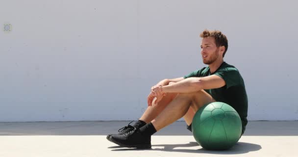 健美运动员男子放松在健身馆的医药球锻炼。健康和积极的生活方式 — 图库视频影像