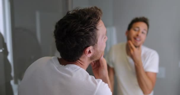 Mężczyzna pielęgnacja twarzy patrząc w lustro dotykając jego brody lub zdrowia skóry - mężczyzna beuaty — Wideo stockowe
