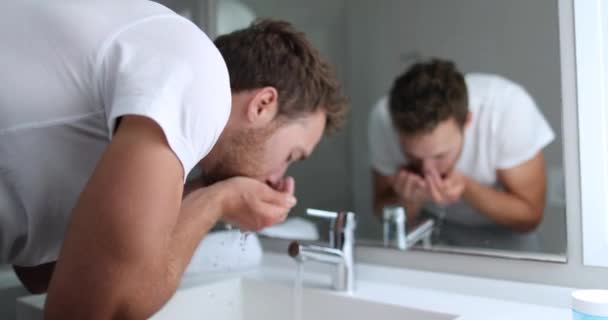 Homem que lava o rosto enxaguando o sabão da pele na pia abaixo da água fria corrente — Vídeo de Stock
