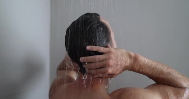Duşta adam saçını yıkıyor banyoda duş alıyor. — Stok video