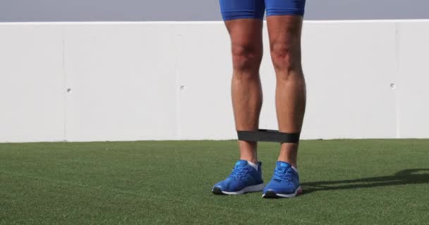 Widerstandsband-Workout-Mann im Fitnessstudio trainiert Muskeln mit Gummibändern — Stockvideo