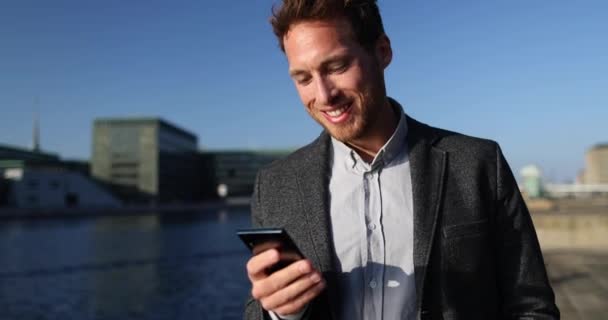 Uomo d'affari utilizzando Smartphone App in Big City Business District Street. — Video Stock