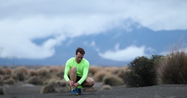 Runner homme attachant des chaussures de course et court sur le sentier à l'extérieur — Video