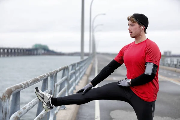 Winter fitness running man warm-up stretching legs — Stock Photo, Image