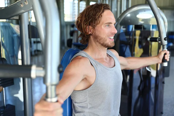 Gym center man tränar på träningsmaskin — Stockfoto