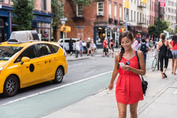 Женщина, гуляющая по Нью-Йорку с помощью приложения для телефона — стоковое фото