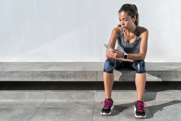 Fitness runner menina usando música aplicativo de telefone móvel — Fotografia de Stock