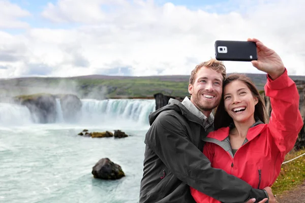 Pareja de viaje tomando foto selfie teléfono en Islandia — Foto de Stock