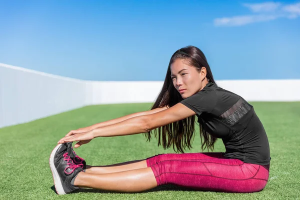 Fitness mulher alongamento sentado dedo do pé esticar toque — Fotografia de Stock