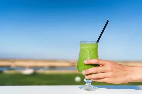 Kvinna som håller grön smoothie glas juice utanför — Stockfoto