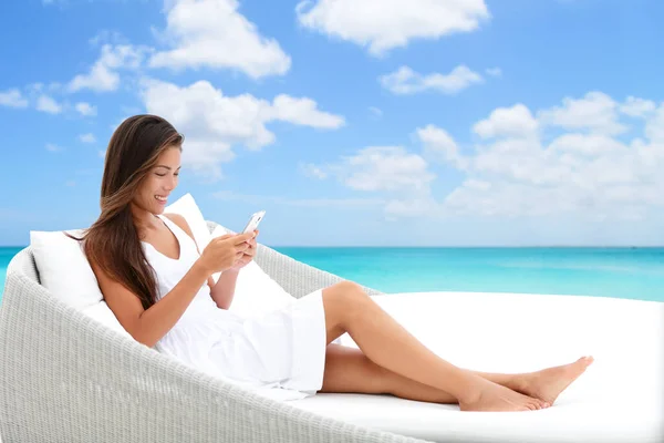 Femme Smartphone utilisant l'application de téléphone sur le canapé de lit de plage — Photo