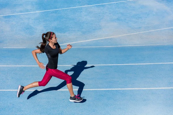 Sportovní běžkyně běžící na atletické běžecké dráze — Stock fotografie