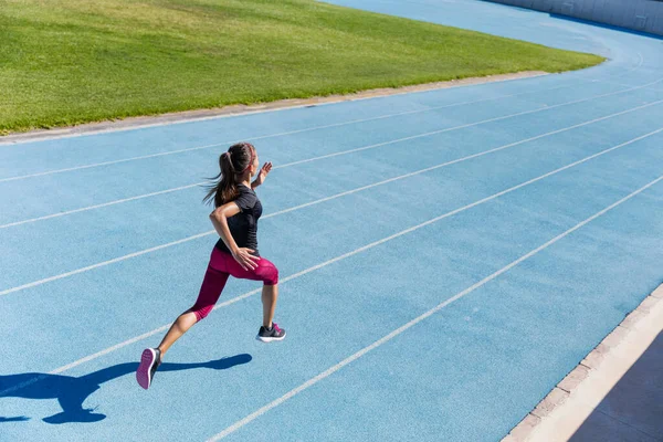 Runner sprinting towards success on running track — Stock Photo, Image