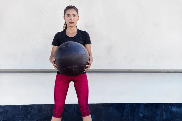 Fitnessstudio-Frau trainiert Arme mit Medizinball — Stockfoto